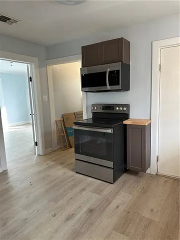 a kitchen with stainless steel appliances a stove and a microwave