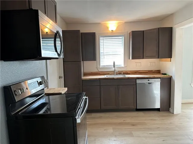 a kitchen with stainless steel appliances granite countertop a sink stove and microwave