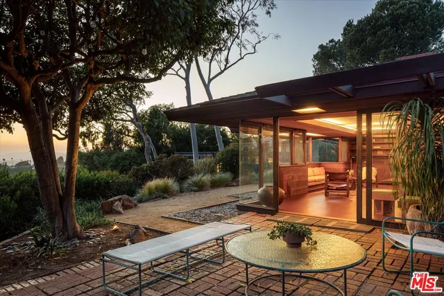 a backyard of a house with yard table and chairs