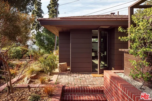 a view of a patio with table and chairs potted plants and large tree