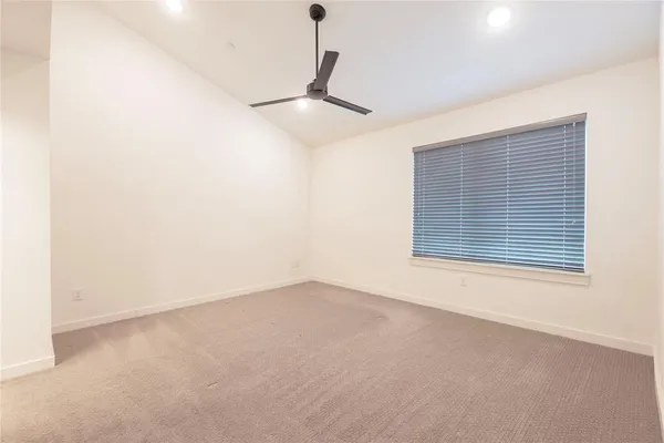 an empty room with a ceiling fan and window