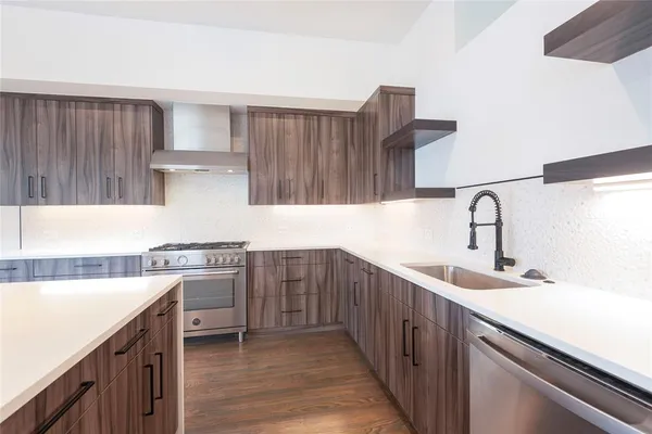 a kitchen with kitchen island a stove a sink and wooden floor