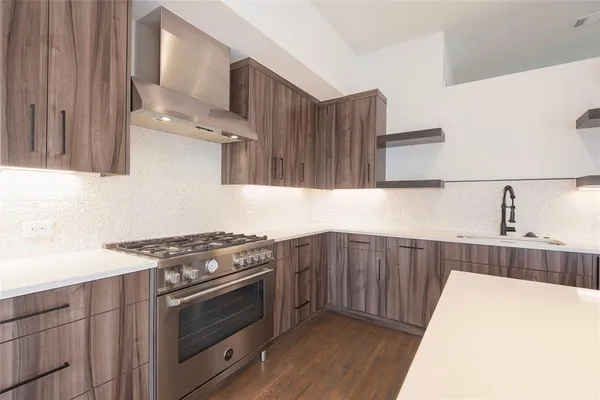 a kitchen with stainless steel appliances a dining table chairs sink and cabinets