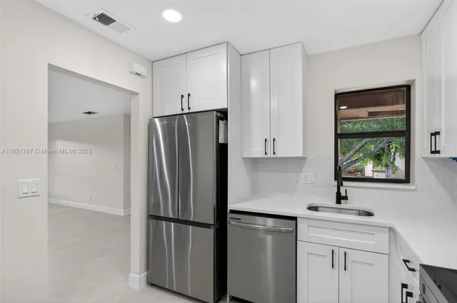 a kitchen with stainless steel appliances a refrigerator sink and cabinets