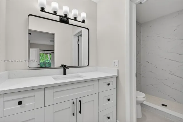 a bathroom with a sink a toilet and shower