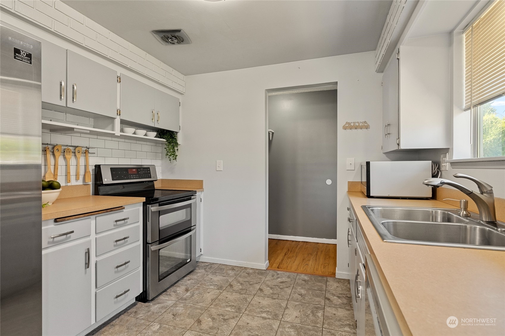 7623 Tyee Road Everett, WA 98203 - Photo 16 of 37 a kitchen with granite countertop a refrigerator and a sink