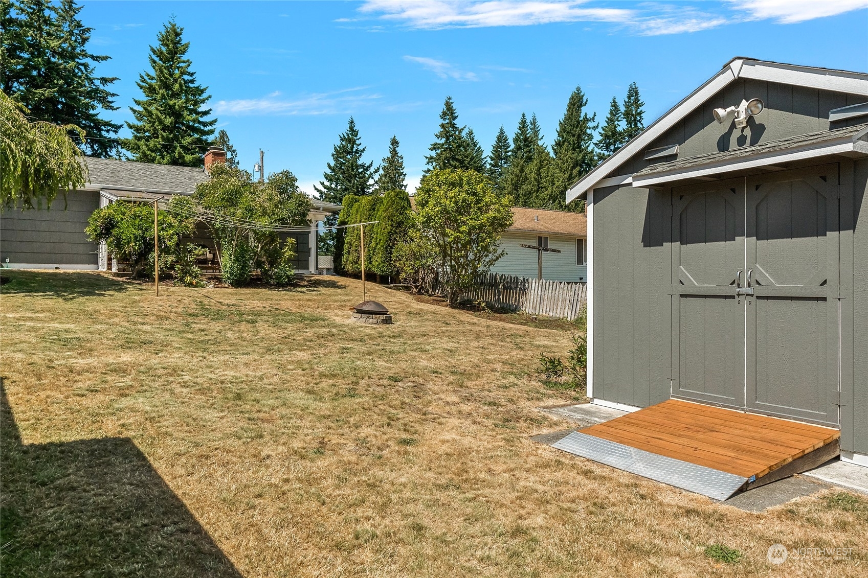 7623 Tyee Road Everett, WA 98203 - Photo 30 of 37 a backyard of a house with large trees and wooden fence
