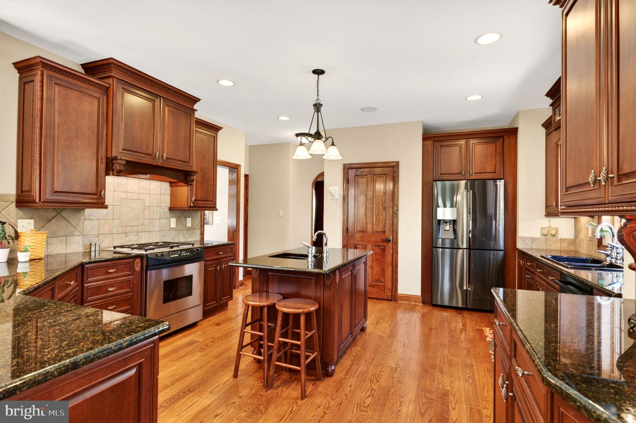 3814 Rocks Station Road Street, MD 21154 - Photo 28 of 70 a kitchen with stainless steel appliances granite countertop a refrigerator a stove top oven a sink dishwasher and wooden cabinets with wooden floor