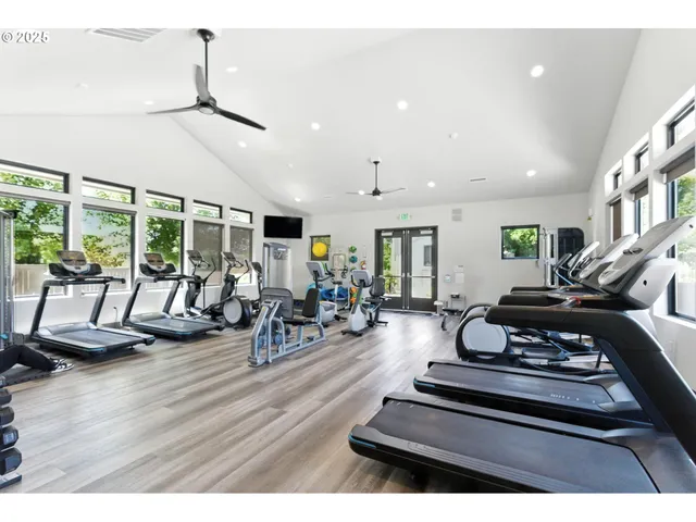 a living room with furniture gym equipment and a large window