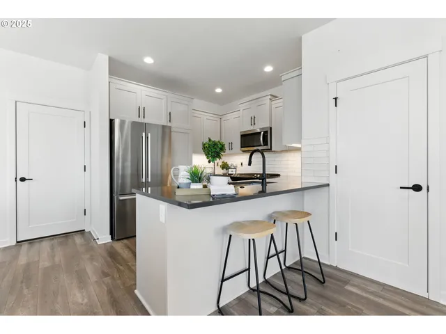 a kitchen with kitchen island a counter top space a sink stainless steel appliances and cabinets