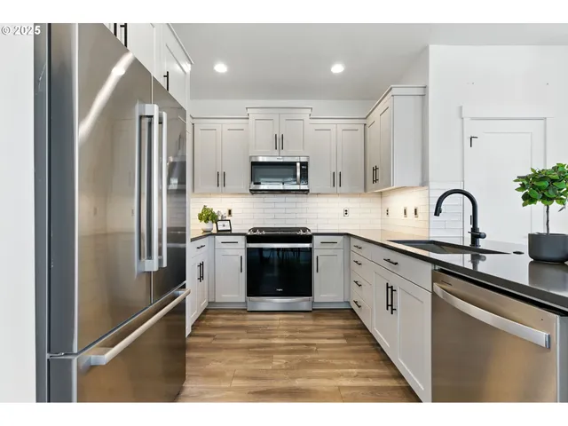a kitchen with granite countertop a refrigerator and a sink