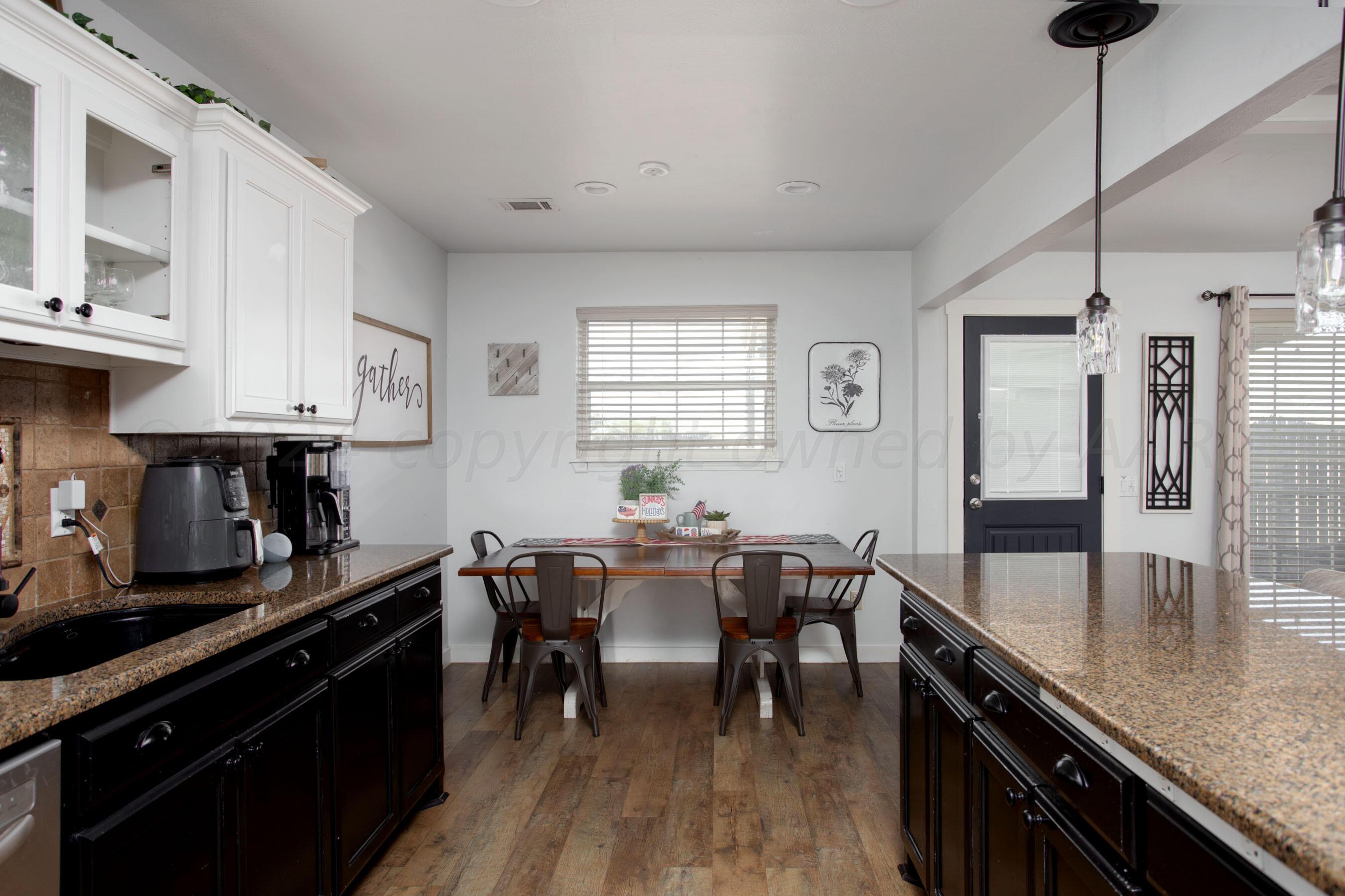5109 Navajo Trail Amarillo, TX 79110 - Photo 14 of 29 a kitchen with granite countertop a dining table chairs sink and cabinets