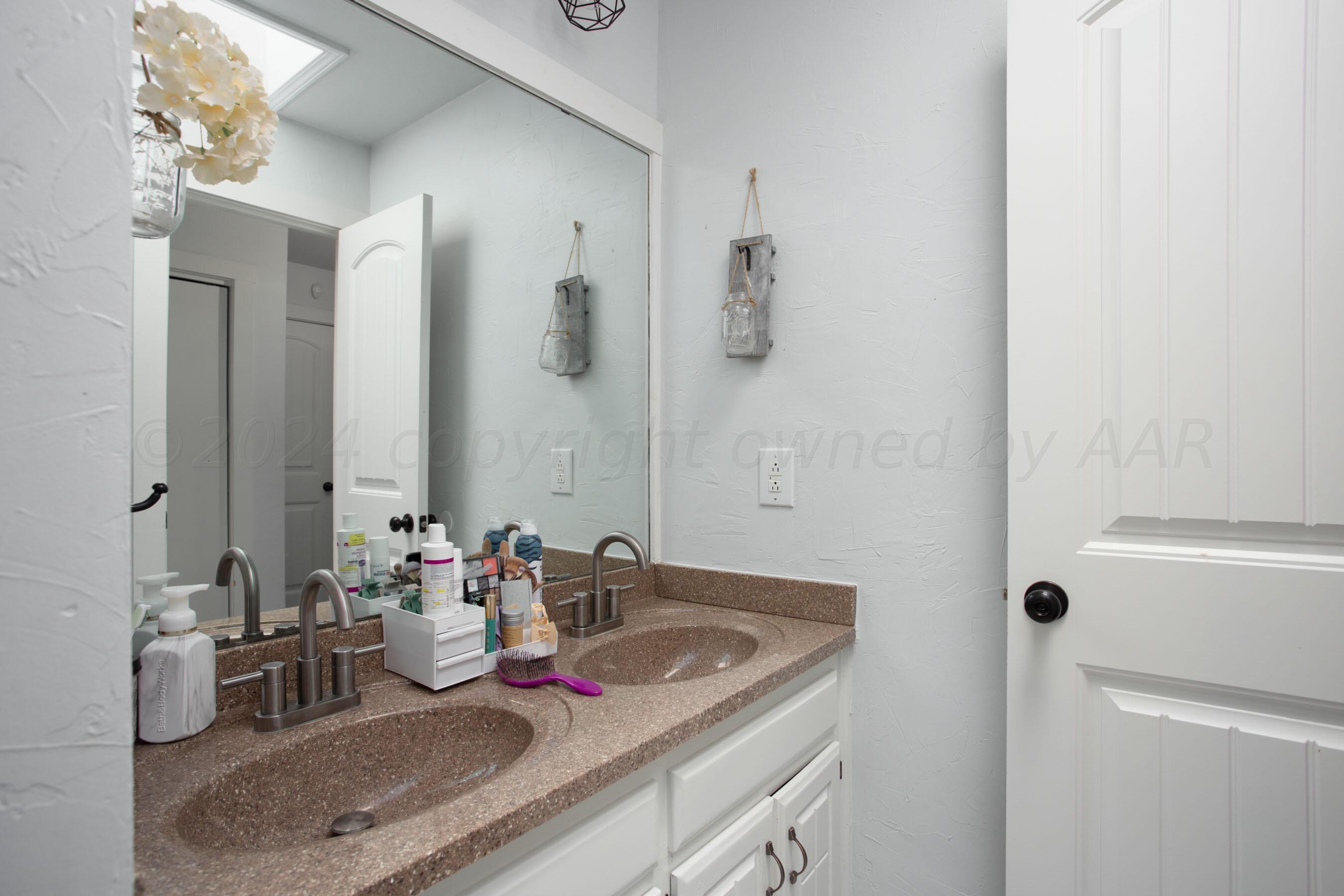 5109 Navajo Trail Amarillo, TX 79110 - Photo 18 of 29 a bathroom with a granite countertop sink and a mirror