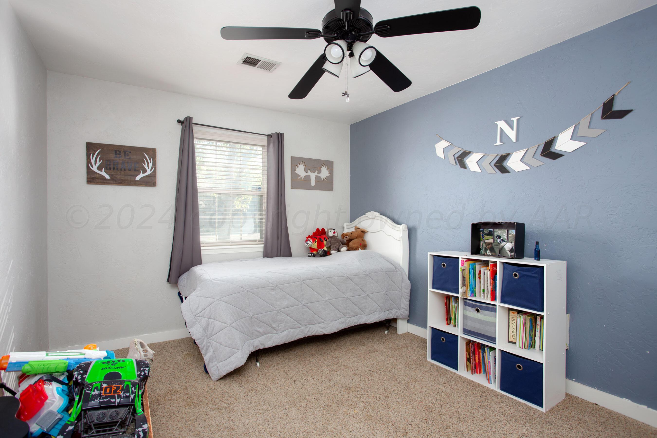 5109 Navajo Trail Amarillo, TX 79110 - Photo 19 of 29 a bedroom with a bed and a chandelier
