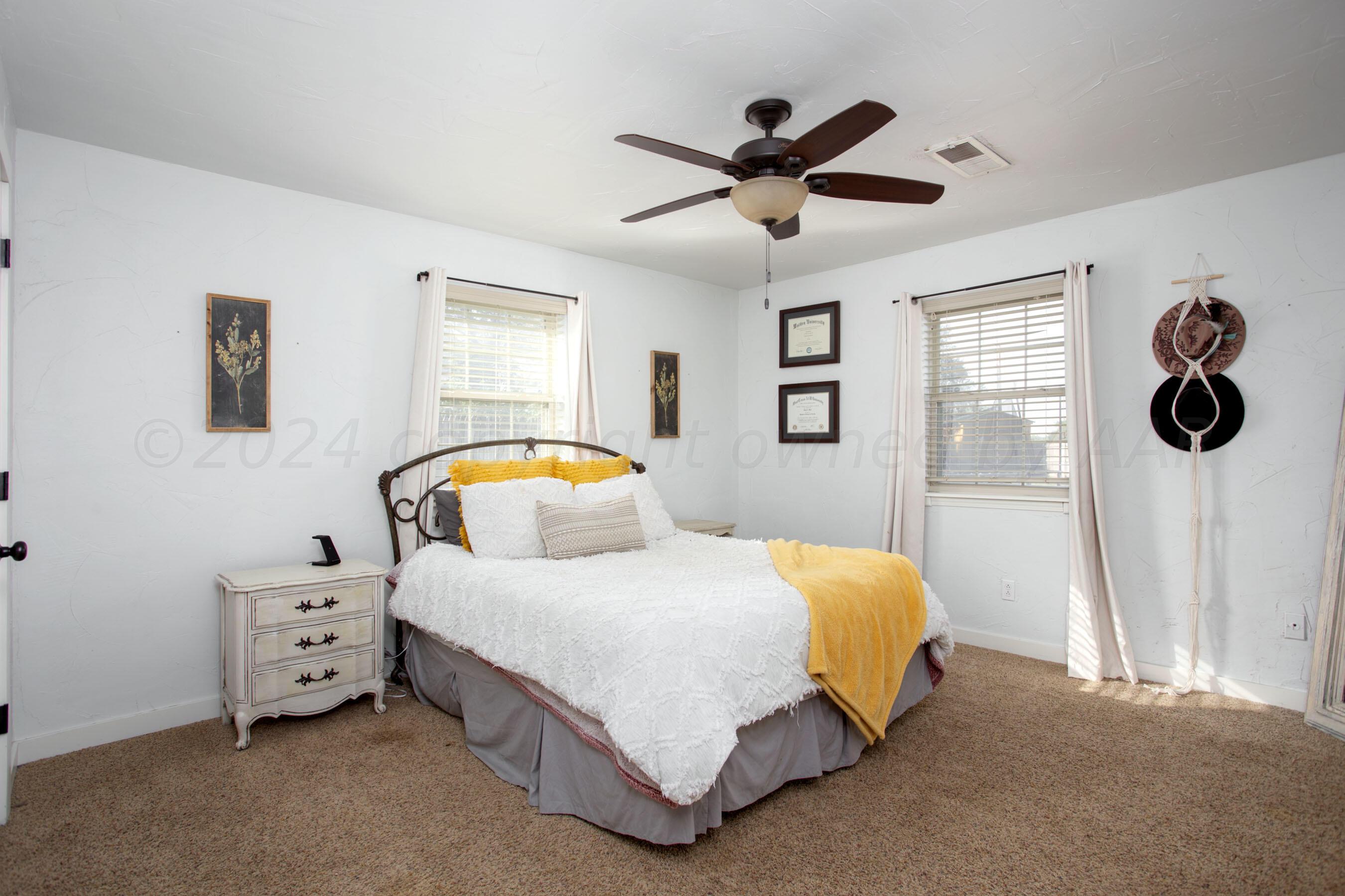 5109 Navajo Trail Amarillo, TX 79110 - Photo 21 of 29 a bedroom with a bed a dresser and a window