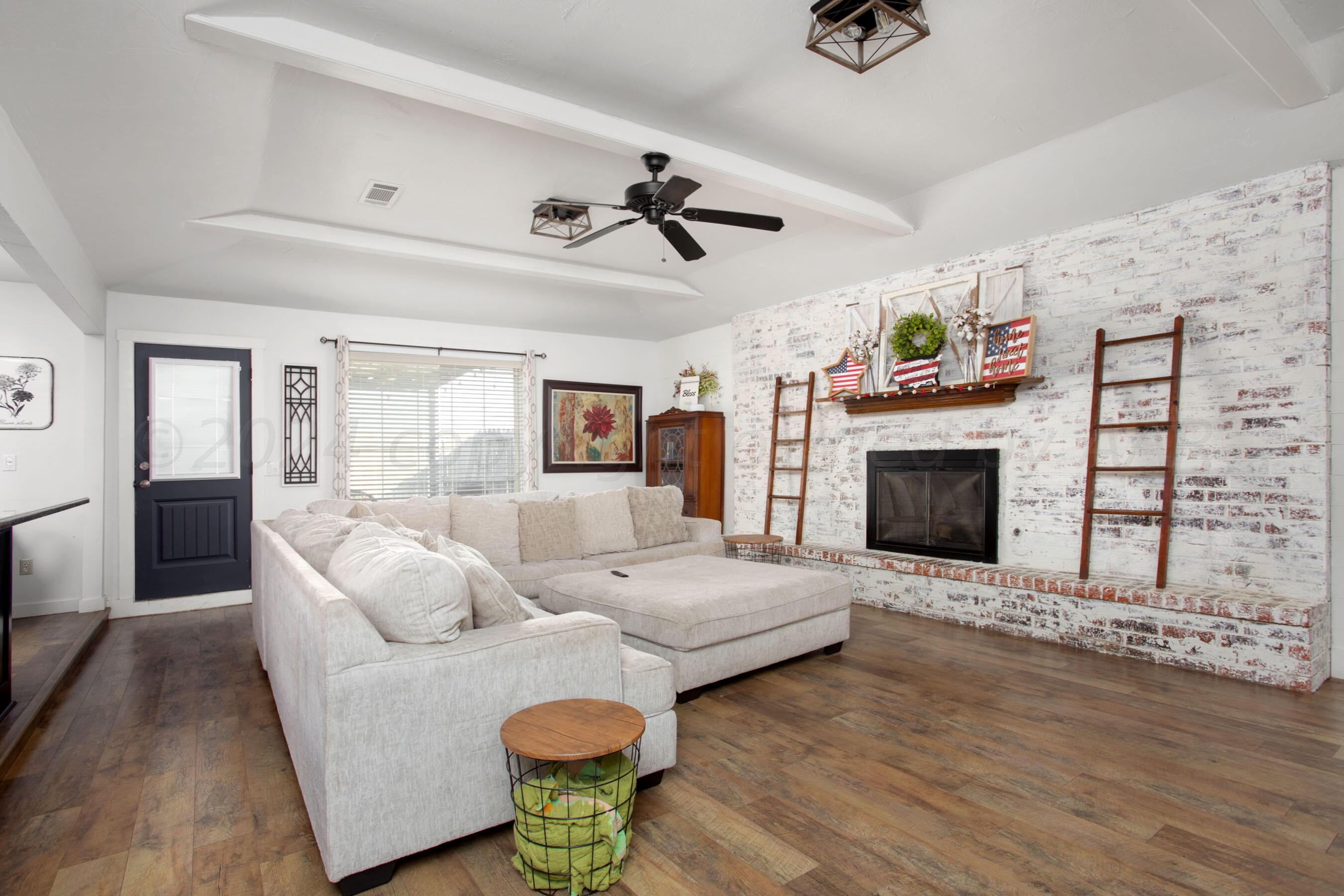 5109 Navajo Trail Amarillo, TX 79110 - Photo 5 of 29 a living room with furniture a fireplace and a flat screen tv