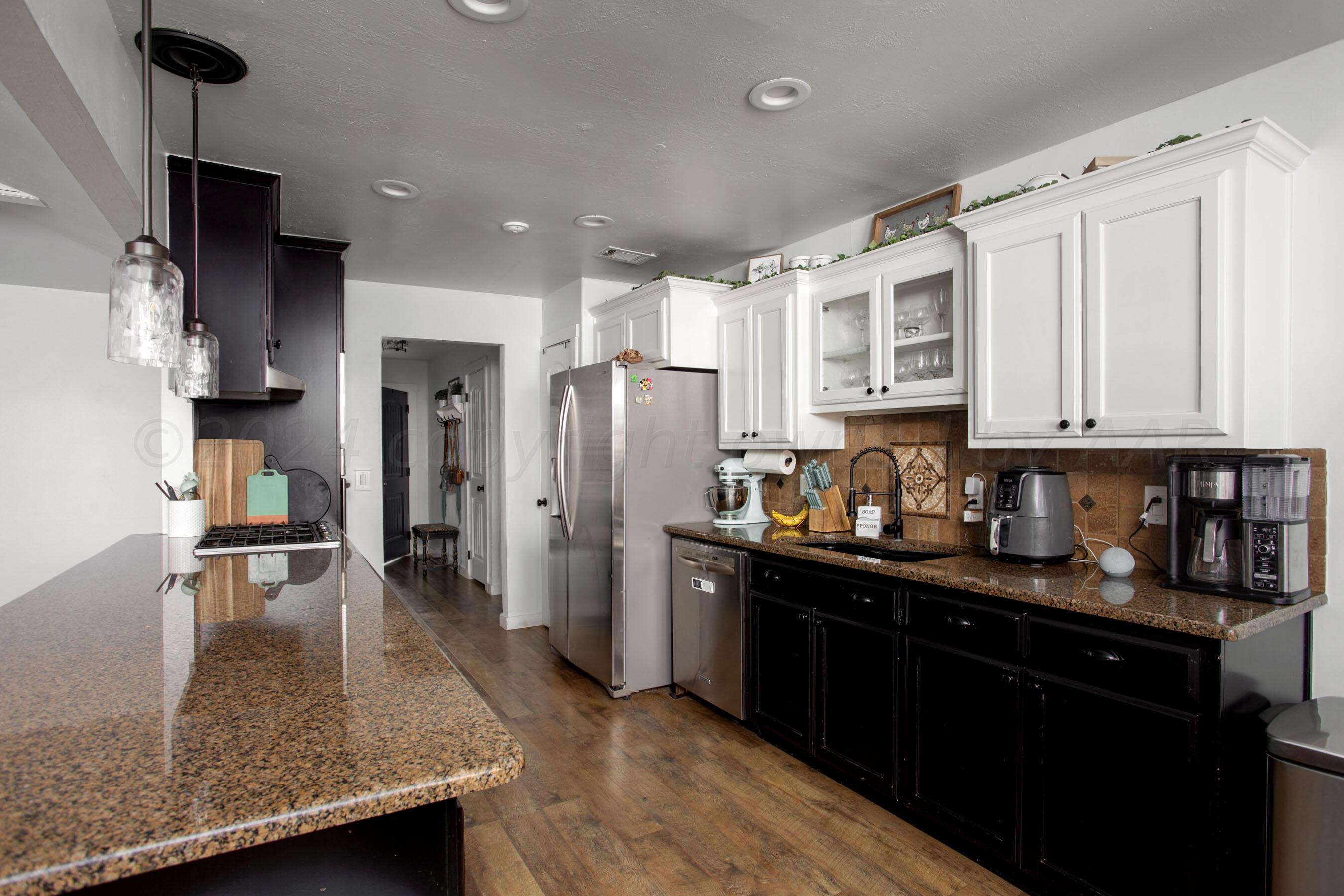 5109 Navajo Trail Amarillo, TX 79110 - Photo 10 of 29 a kitchen with stainless steel appliances granite countertop a refrigerator a sink dishwasher a stove and white cabinets