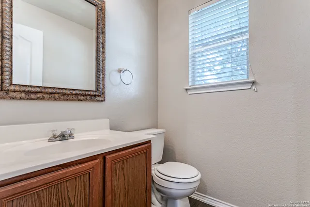 a bathroom with a sink mirror and toilet