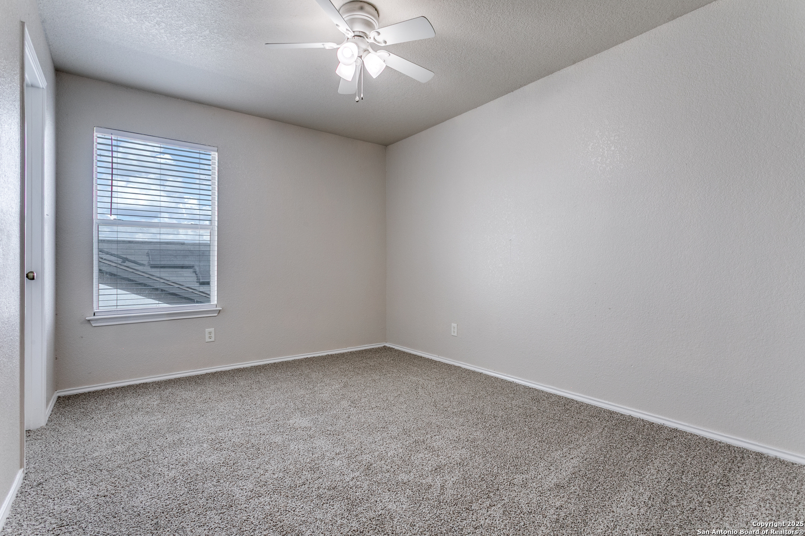 6609 Wood Bench Live Oak, TX 78233 - Photo 18 of 23 en empty room with windows and chandelier fan