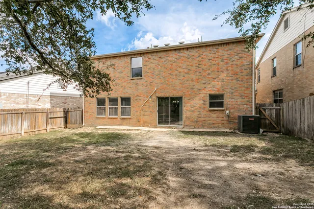 a view of a house with backyard and a tree