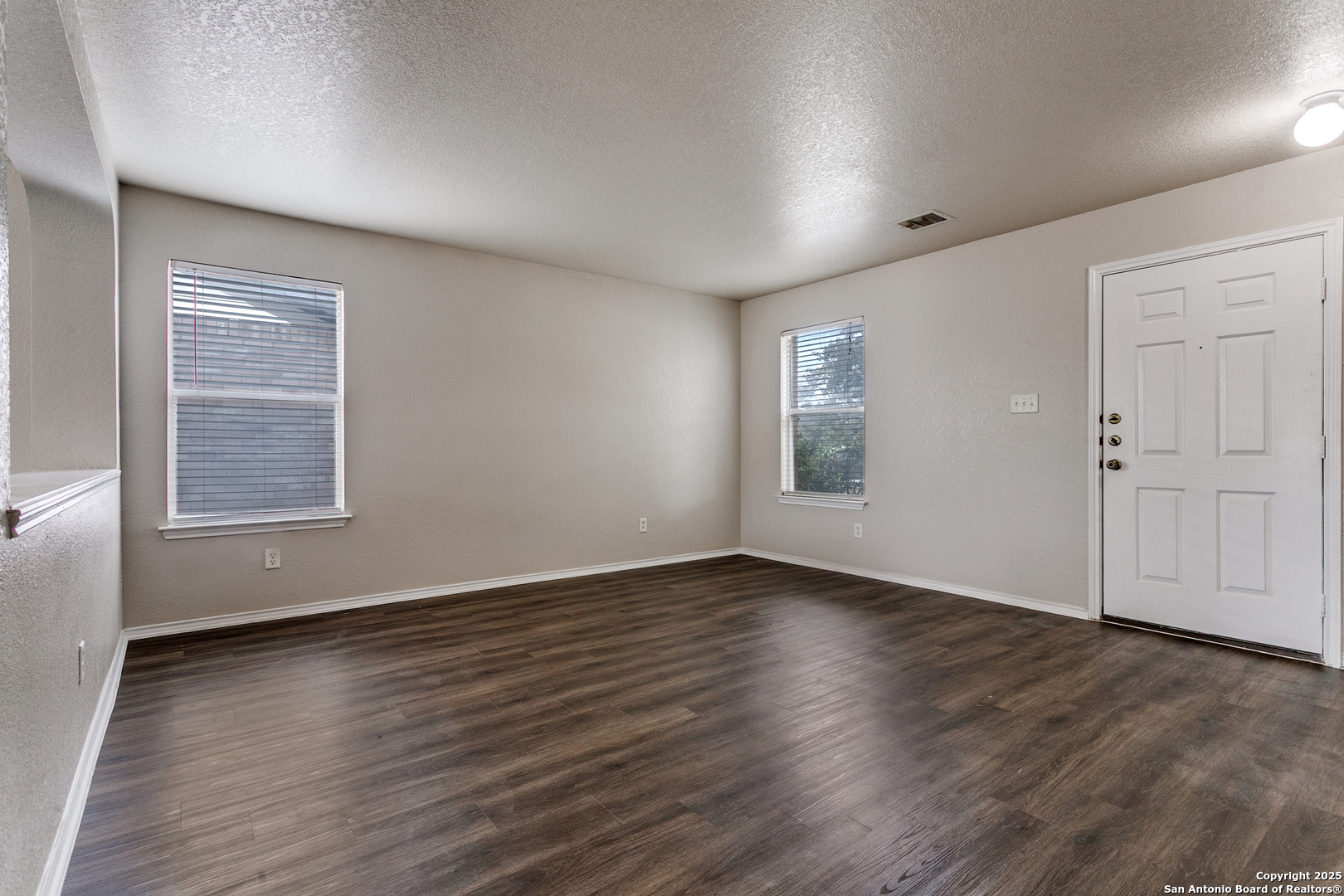 6609 Wood Bench Live Oak, TX 78233 - Photo 3 of 23 an empty room with wooden floor and windows