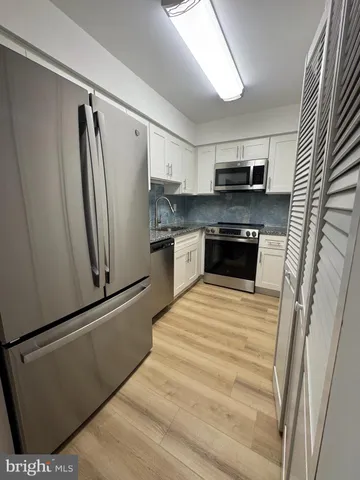 a kitchen with stainless steel appliances a refrigerator sink and microwave