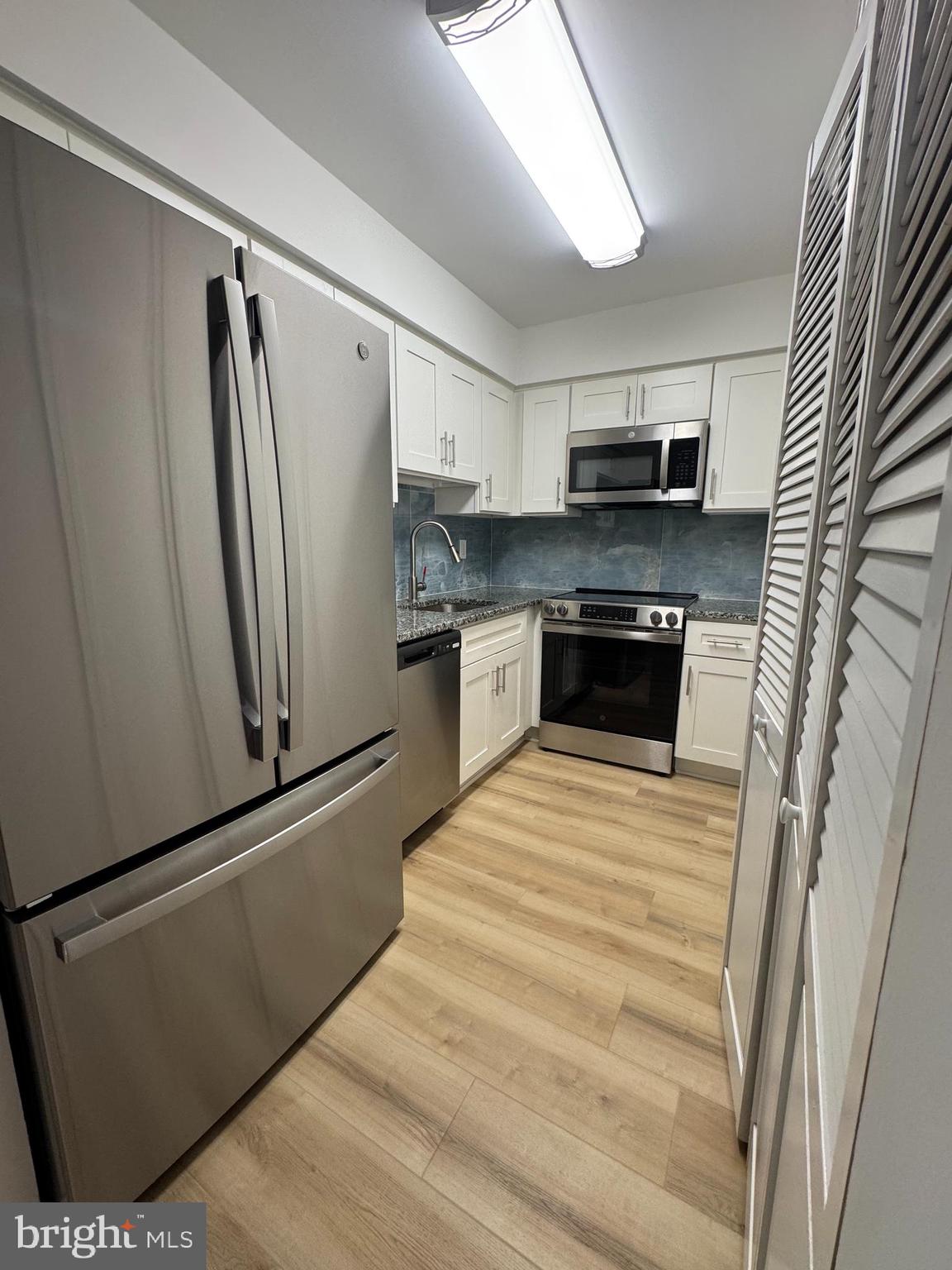a kitchen with stainless steel appliances a refrigerator sink and microwave