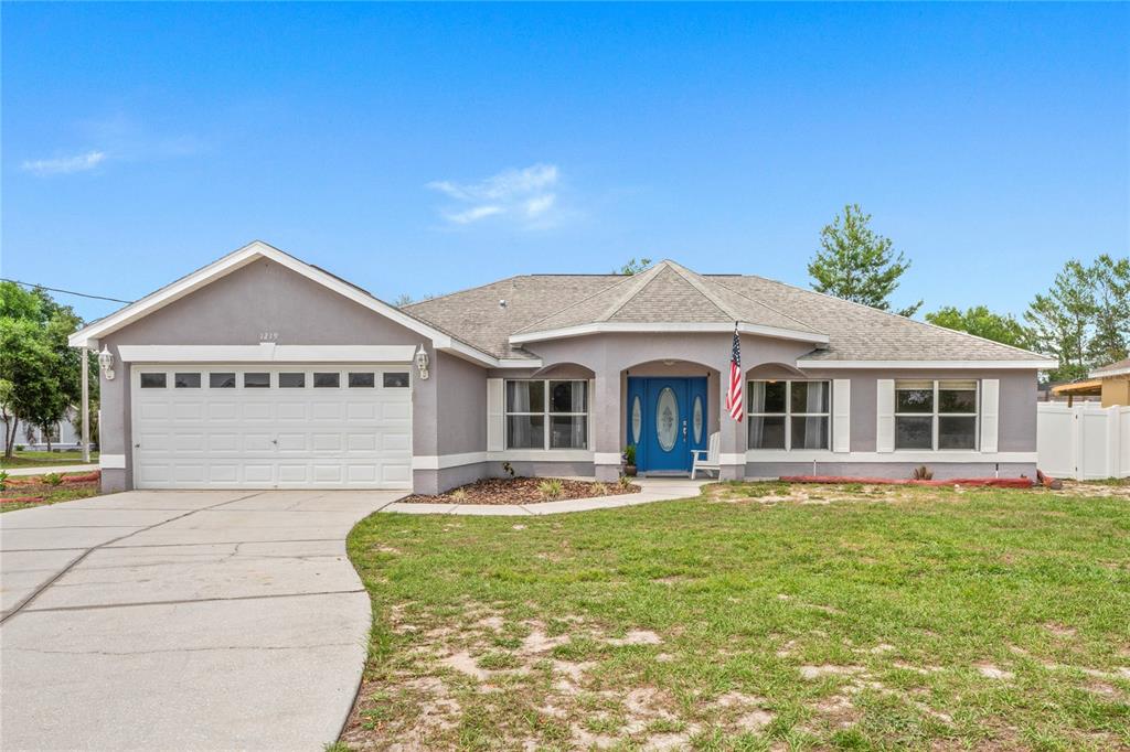 1219 Aladdin Road Spring Hill, FL 34609 - Photo 1 of 1 a front view of a house with a yard table and chairs
