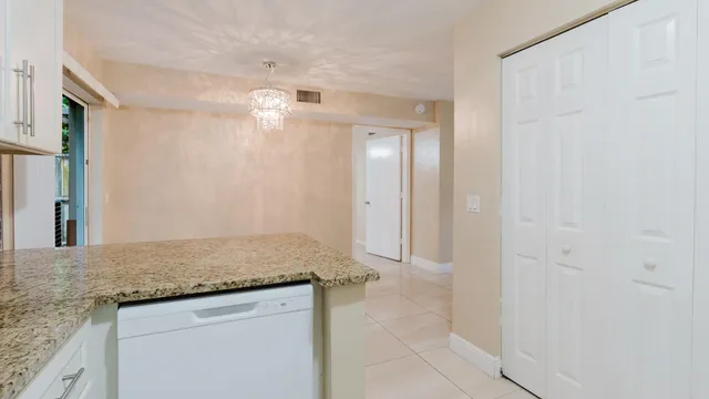 a kitchen with granite countertop white cabinets and white appliances
