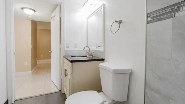 a bathroom with a granite countertop sink toilet and shower
