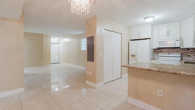a kitchen with granite countertop a refrigerator and a stove top oven