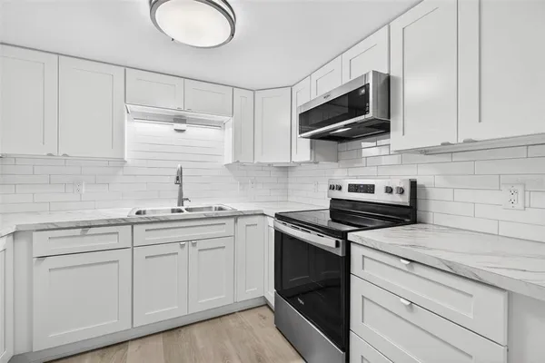 a kitchen with cabinets and stainless steel appliances