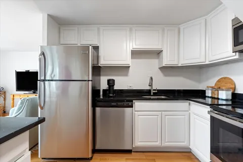 a kitchen with stainless steel appliances granite countertop a refrigerator and a stove