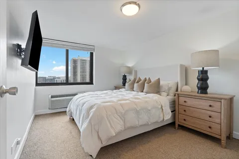 a bedroom with a large bed and a flat tv screen on a dresser