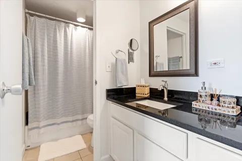 a bathroom with a granite countertop sink and a mirror
