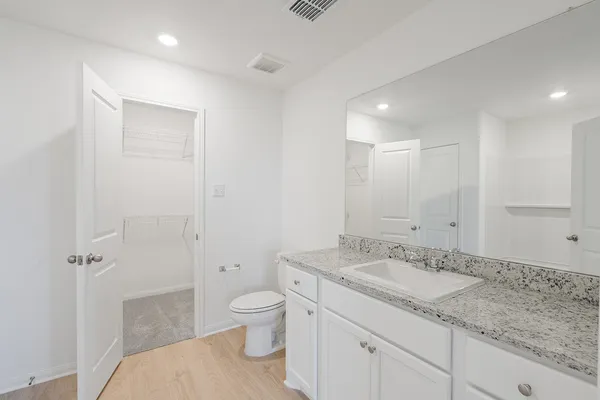a spacious bathroom with a granite countertop sink a toilet and shower