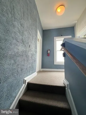 an empty room with kitchen and windows