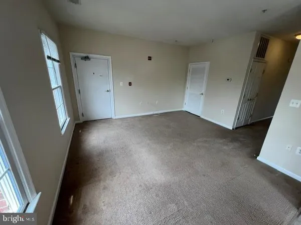 an empty room with windows and ceiling fan