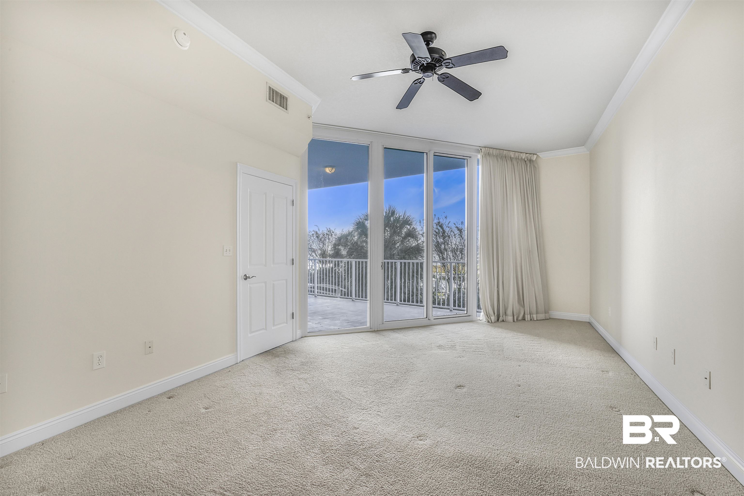 28250 Canal Road, Unit 106 Orange Beach, AL 36561 - Photo 12 of 50 Carpeted empty room featuring crown molding and a ceiling fan
