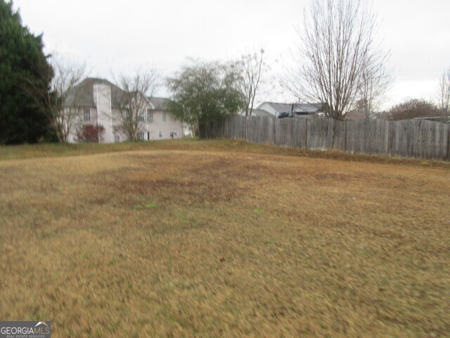12237 Dickson Road Hampton, GA 30228 - Photo 13 of 14 a view of yard with tree and wooden fence