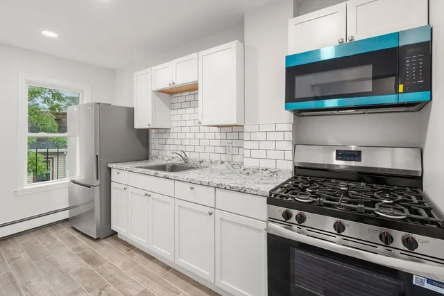 a kitchen with stainless steel appliances granite countertop a stove and a microwave