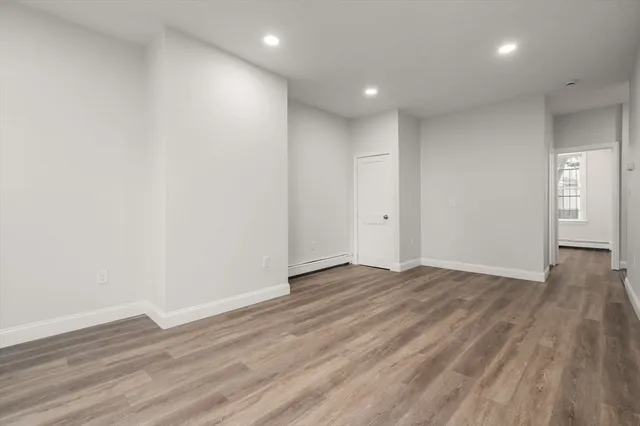 a view of an empty room with wooden floor