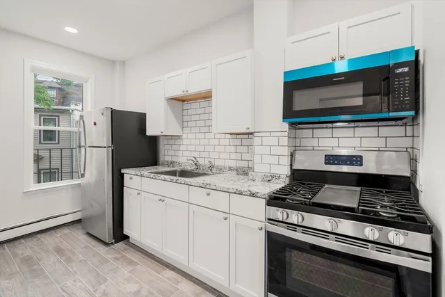 a kitchen with stainless steel appliances a stove microwave and sink