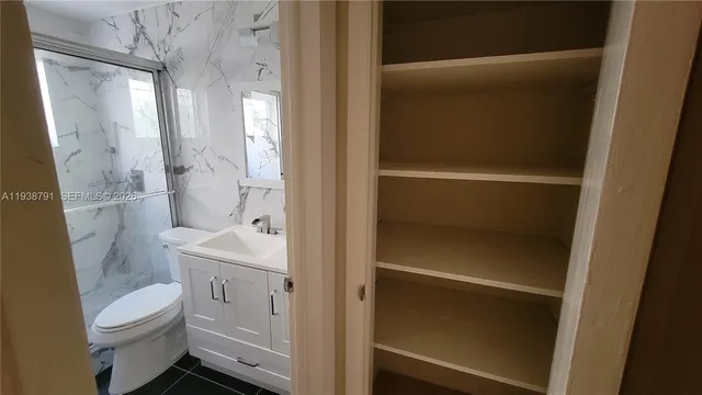 a bathroom with a granite countertop sink toilet and shower