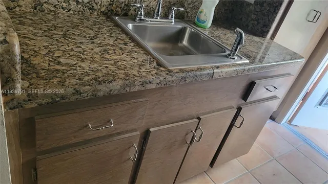 a kitchen with granite countertop a sink and cabinets