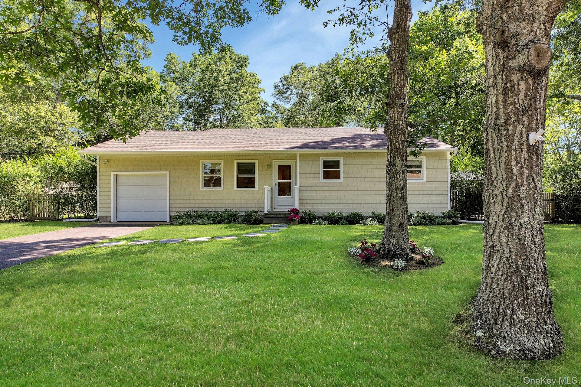 38 Woodridge Road Hampton Bays, NY 11946 - Photo 1 of 24 front view of a house with a yard