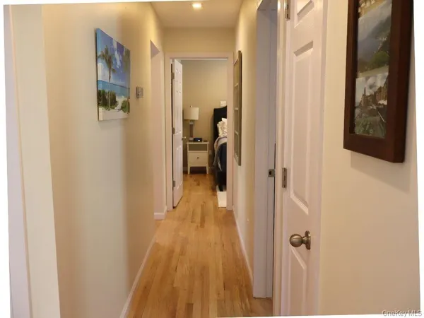 a view of a hallway with wooden floor and closet