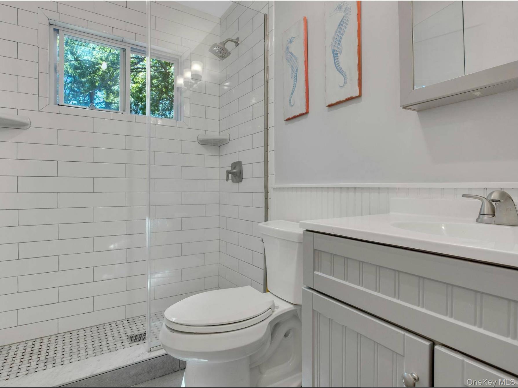 38 Woodridge Road Hampton Bays, NY 11946 - Photo 15 of 24 a bathroom with a sink a toilet and window