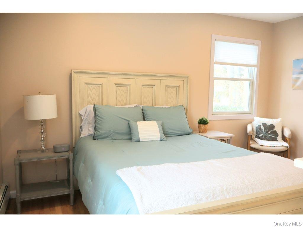 38 Woodridge Road Hampton Bays, NY 11946 - Photo 17 of 24 a bedroom with a bed and a night stand