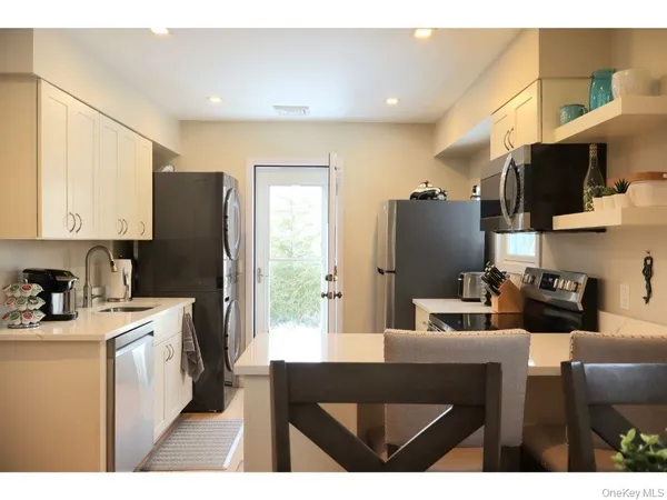 a kitchen with stainless steel appliances a stove refrigerator sink microwave and cabinets